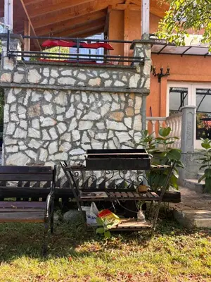 a bench sitting in front of a stone building at Kuća za odmor braća Jevtić Vrnjačka Banja in Vrnjačka Banja