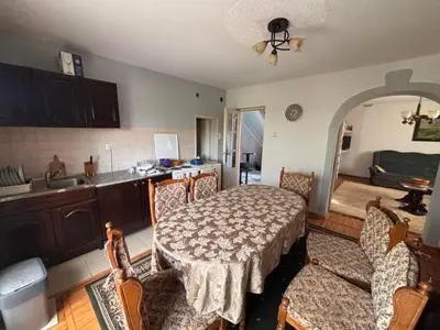 a kitchen with a table and chairs and a kitchen with a sink at Kuća za odmor braća Jevtić Vrnjačka Banja in Vrnjačka Banja