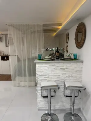 a kitchen with two stools in front of a counter at SpaNish apartman 5 in Niš
