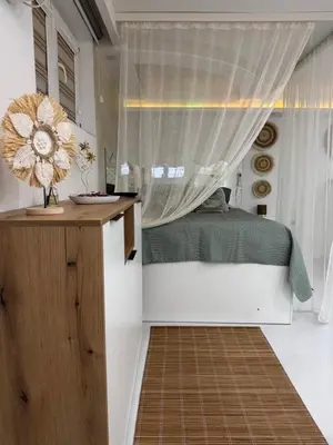 a bedroom with a bed and a window with a curtain at SpaNish apartman 5 in Niš