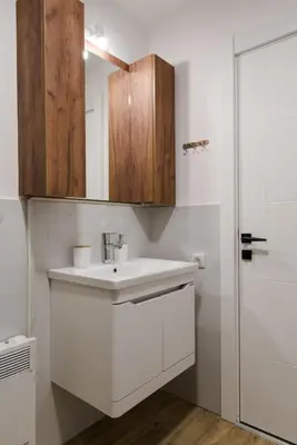 a white bathroom with a sink and a shower at Dina LUX apartman in Vrnjačka Banja