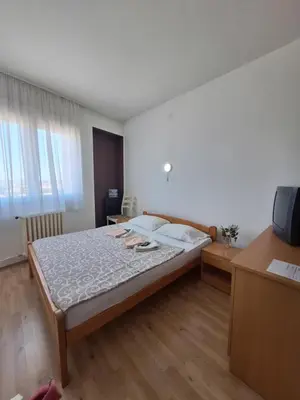 a bedroom with a bed and a desk and a television at Hotel Konaciste Trstenik in Trstenik