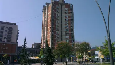 a tall building in the middle of a city at Hotel Konaciste Trstenik in Trstenik