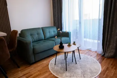 a living room with a couch and a table at Apartman A PLUS in Vranje