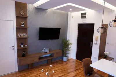 a living room with a flat screen tv on a wall at Apartman A PLUS in Vranje