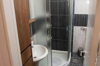 a small bathroom with a shower and a sink at Apartman A PLUS in Vranje