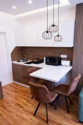a kitchen with a white table and two chairs at Apartman A PLUS in Vranje
