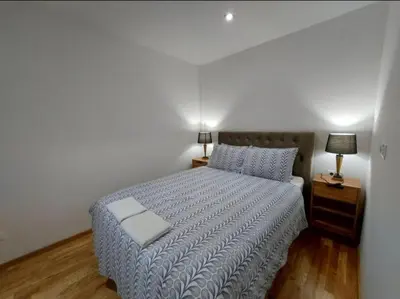 a bedroom with a bed with a blue comforter at Apartmani Katnic in Jagodina