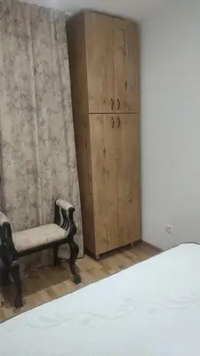 a bedroom with a chair and a cabinet at Apartmani Katnic in Jagodina