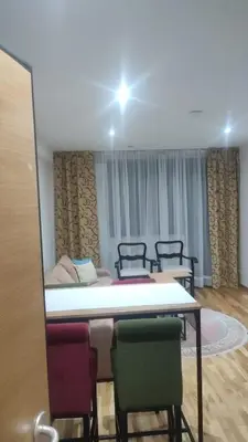 a room with a bed and a table and chairs at Apartmani Katnic in Jagodina