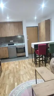 a kitchen with a table and chairs in a room at Apartmani Katnic in Jagodina