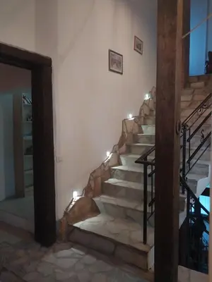 a stone staircase in a house with lights at Dvorac Castelo DB 2022 in Vrnjačka Banja