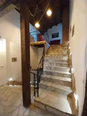 a staircase in a building with stone floors and a wooden beam at Dvorac Castelo DB 2022 in Vrnjačka Banja