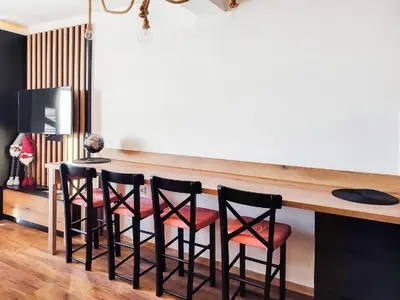 a kitchen with a bar with four stools at Kopaonik,President kop app 404 in Kopaonik