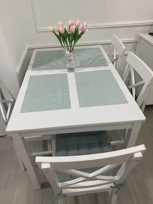 a white table with a vase with pink flowers on it at LoKA apartman in Paraćin