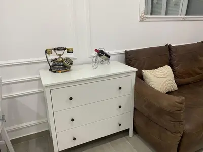 a white chest of drawers next to a couch at LoKA apartman in Paraćin