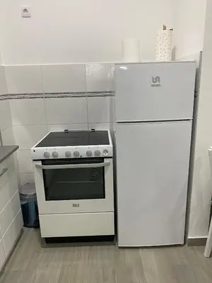 a white stove and refrigerator in a kitchen at LoKA apartman in Paraćin