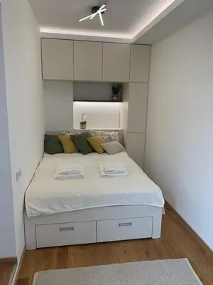 a bedroom with a bed with white walls and a ceiling at Apartment Jovic in Niš