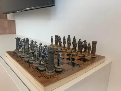 a chess set on a wooden chessboard on a table at Apartment Jovic in Niš