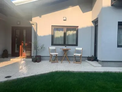 a patio with two chairs and a table in front of a house at Apartment Jovic in Niš
