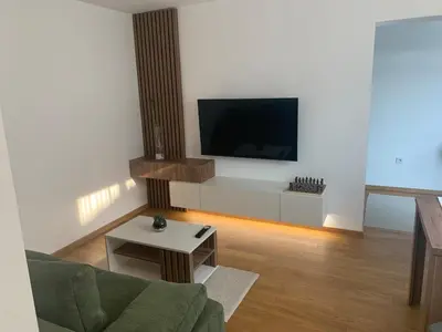 a living room with a tv and a couch and a table at Apartment Jovic in Niš