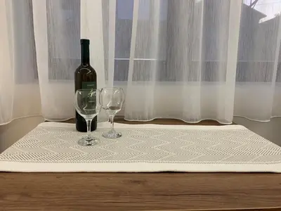 a bottle of wine and two glasses on a table at Apartment Jovic in Niš