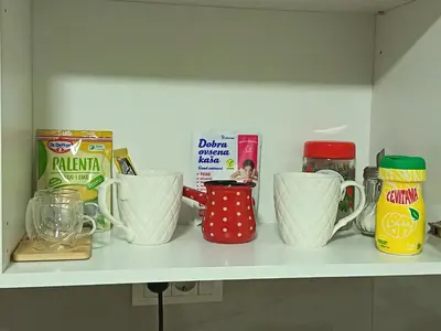 a shelf with cups and other kitchen items on it at Eva Apartman in Prokuplje