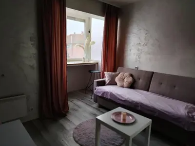 a living room with a couch and a table and a window at Eva Apartman in Prokuplje