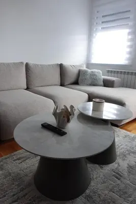 a living room with a table and a couch at Niš Deluxe in Niš