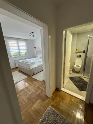 a bedroom with a bed and a toilet and a mirror at Niš Deluxe in Niš