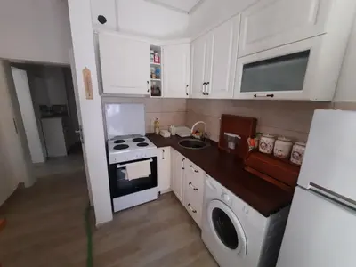 a small kitchen with a stove and a sink at Sunčana oaza in Vrnjačka Banja