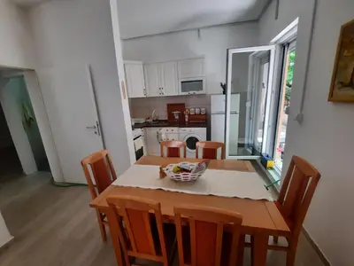 a kitchen and dining room with a table and chairs at Sunčana oaza in Vrnjačka Banja