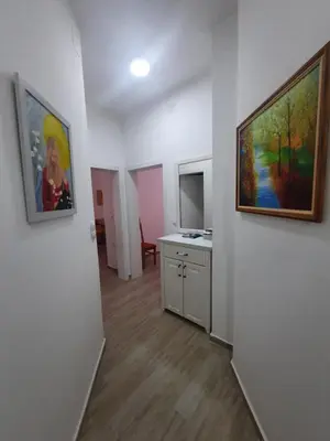 a room with two paintings on the wall and a kitchen at Sunčana oaza in Vrnjačka Banja