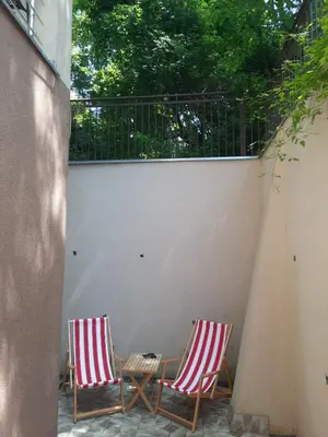 two chairs sitting on a patio next to a fence at Sunčana oaza in Vrnjačka Banja