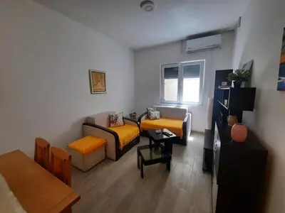 a living room with two couches and a table at Sunčana oaza in Vrnjačka Banja