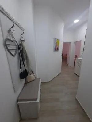 a room with a hallway with white walls and wooden floors at Sunčana oaza in Vrnjačka Banja