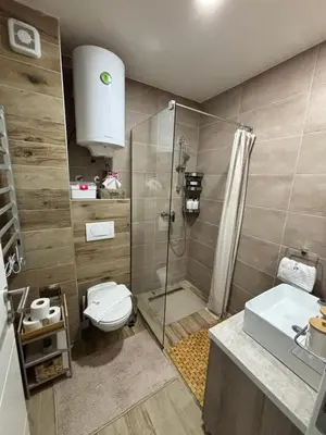 a bathroom with a shower and a toilet and a sink at Milmari Resort & Spa Kopaonik NLux 72a in Kopaonik