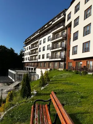 a park bench in front of a large building at Milmari Resort & Spa Kopaonik NLux 72a in Kopaonik