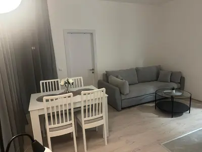 a living room with a couch and a table and chairs at Apt1- Sokobanjica apartmani in Soko Banja