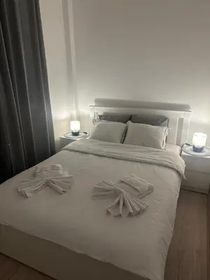 a white bed with two towels on top of it at Apt1- Sokobanjica apartmani in Soko Banja