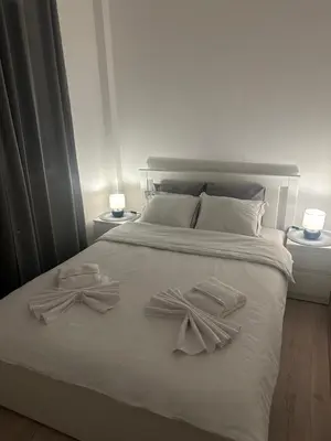 a white bed with two towels on top of it at Apt1- Sokobanjica apartmani in Soko Banja