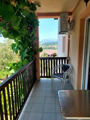 a balcony with a table and chairs and a refrigerator at Vila Ramona Sokobanja in Soko Banja