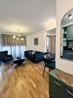 a living room with a black couch and chairs at Apartman My Dream in Vrnjačka Banja