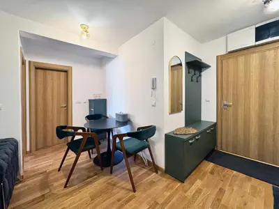 a living room with a table and chairs in a room at Apartman My Dream in Vrnjačka Banja