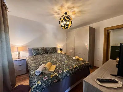 a bedroom with a bed and a chandelier at Apartman My Dream in Vrnjačka Banja
