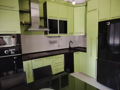 a kitchen with green cabinets and a black refrigerator at Sofi in Jagodina