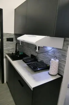 a kitchen with a counter with a stove and a light at Apartman Dzunic in Pirot