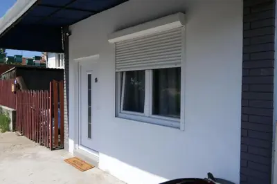 a window with a shutter on a white wall at Apartman Dzunic in Pirot