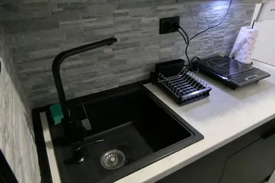 a kitchen counter with a sink and a stove at Apartman Dzunic in Pirot