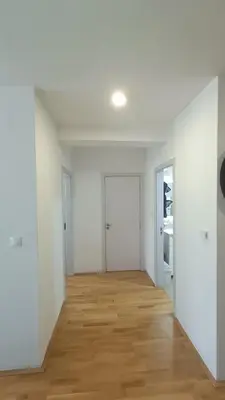 an empty room with white walls and a wooden floor at Apartman Centrala Lux in Pirot